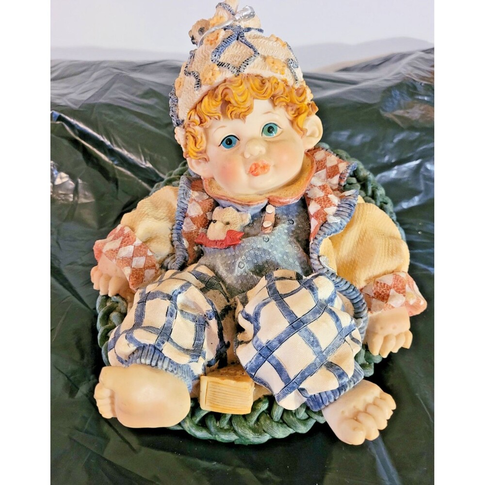 Winter Garden Baby Sitting In Blue Wicker Basket Resin